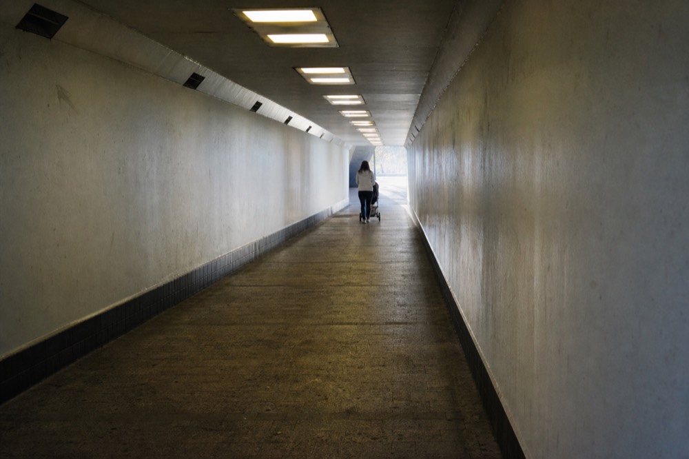 Underground pedestrian tunnel with lighting leading toward a convention centre exit, no text, no logos, no people