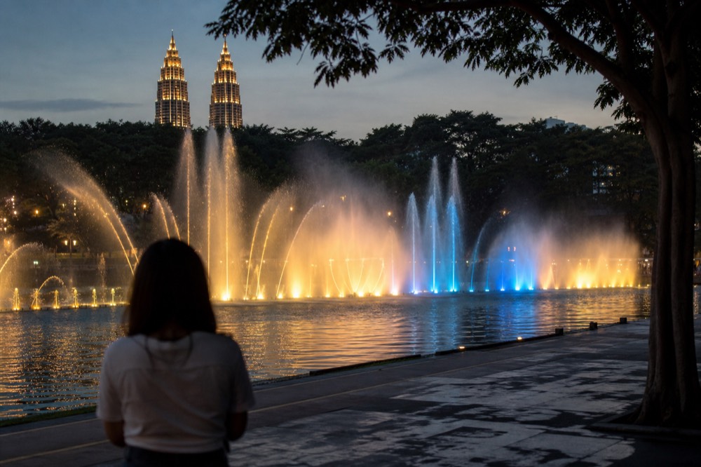 Lake Symphony fountain spraying water in front of lit twin towers at night, no text, no logos, no people
