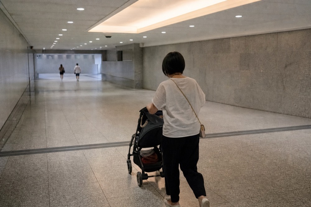 Covered walkway inside a shopping mall with a stroller, no text, no logos, no people
