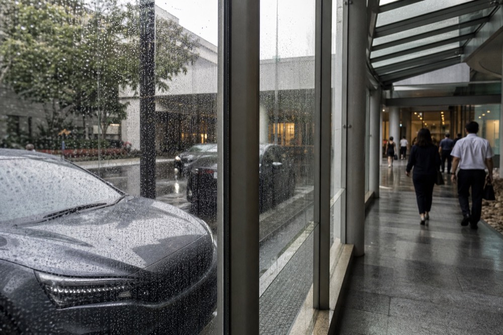 A covered city walkway with glass walls leading toward a convention centre, no text, no logos, no people