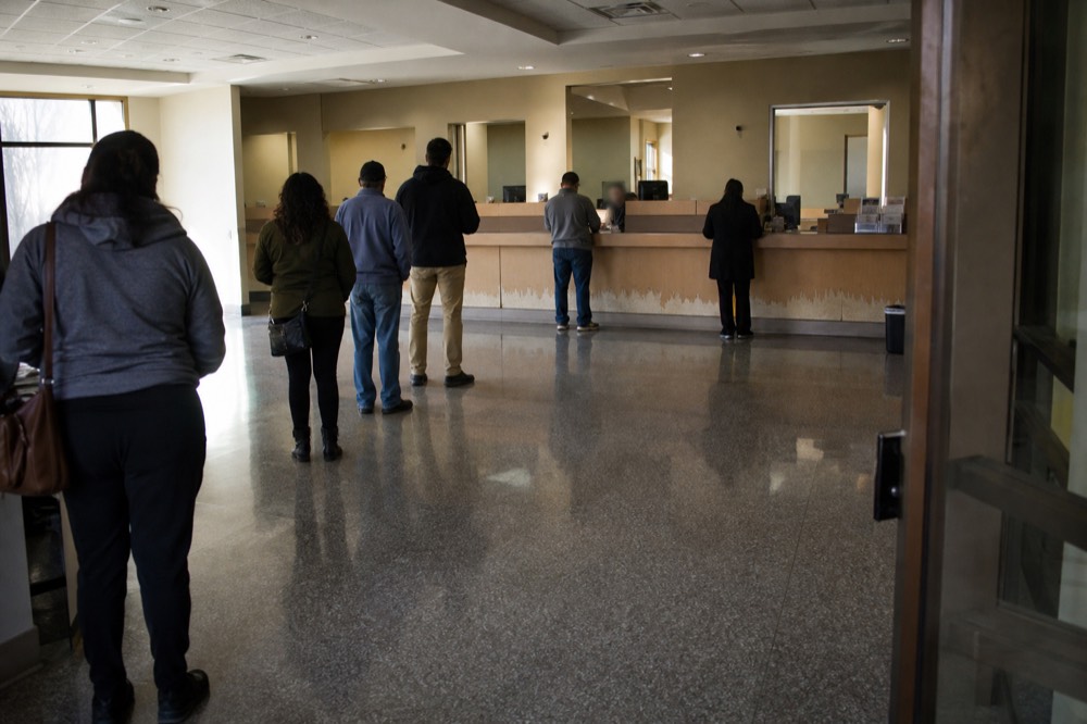 Ticket counter queue at an aquarium entrance with staffed desks, no text, no logos, no people