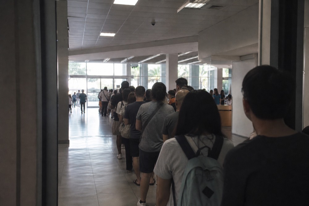 Long queue of visitors waiting outside an aquarium entrance, no text, no logos, no people