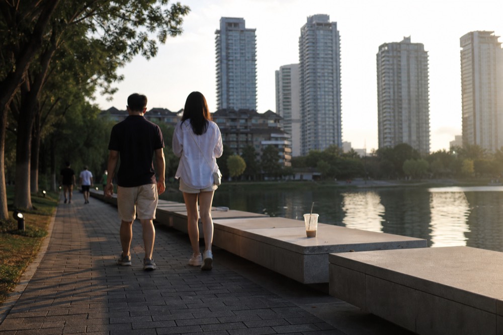Visitors walking beside the lake at KLCC Park with the towers behind, no text, no logos, no people