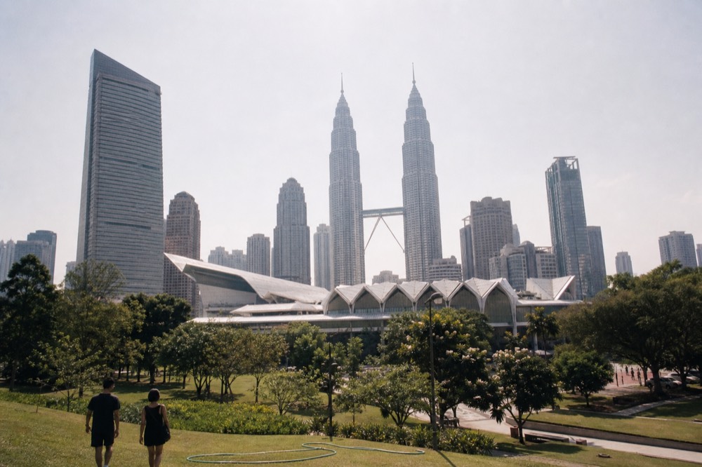 KLCC precinct at midday with the Convention Centre and towers above, no text, no logos, no people