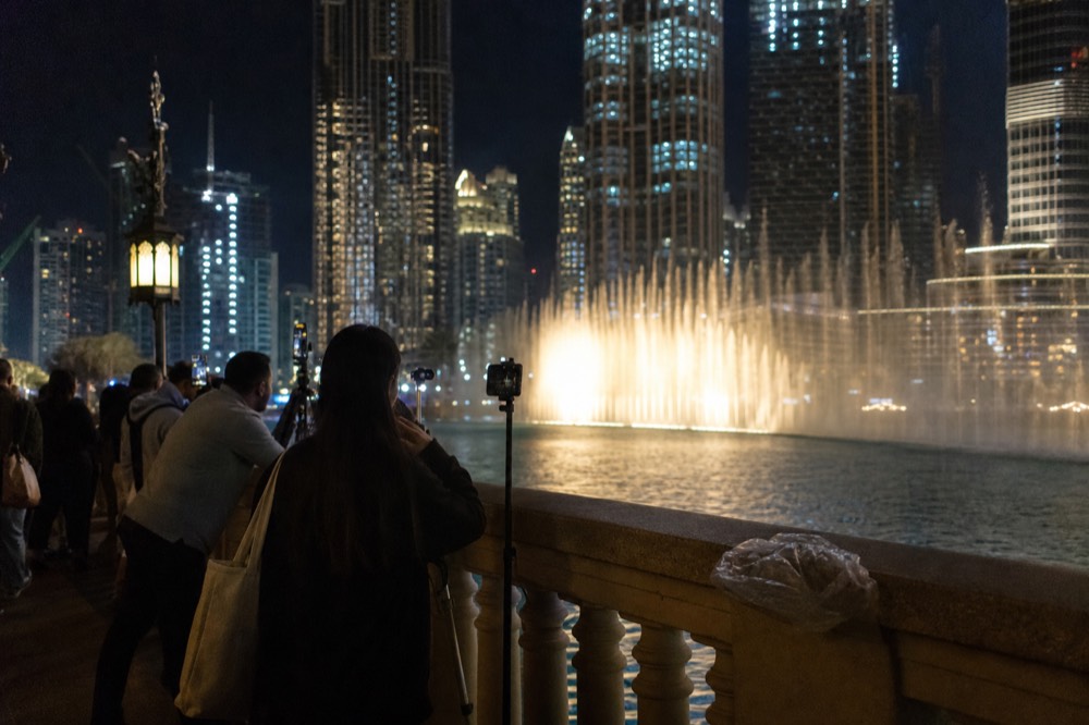 The Lake Symphony fountain spraying water in front of the illuminated Petronas Twin Towers at night, no text, no logos, no people