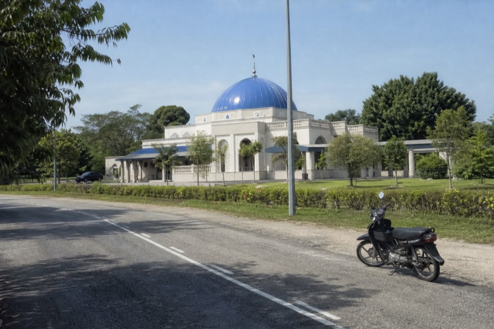 Blue-domed Masjid Asy-Syakirin mosque at the edge of KLCC Park in daylight, no text, no logos, no people