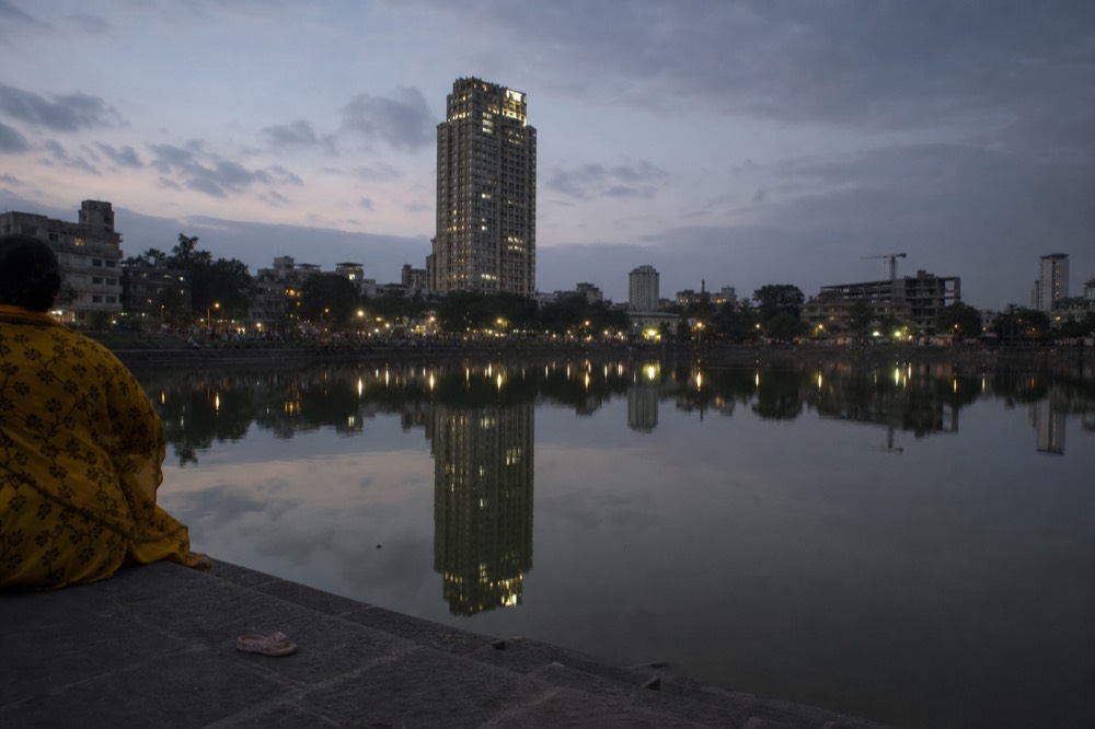 Lake edge at dusk with the illuminated towers reflected in the water before the fountain show, no text, no logos, no people