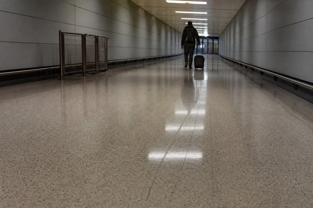 Covered walkway with polished floor leading toward glass doors, no text, no logos, no people